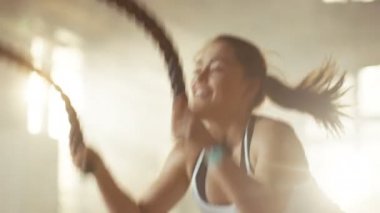 Bir spor salonunda atletik erkek egzersizleri ile savaş ipler onun çapraz Fitness Egzersiz sırasında / yoğun aralığı eğitim. O kas ve terli, spor salonu sanayi yapılar.