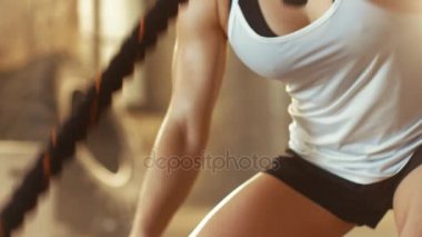 Bir spor salonunda atletik erkek egzersizleri ile savaş ipler onun çapraz Fitness Egzersiz sırasında / yoğun aralığı eğitim. O kas ve terli, spor salonu sanayi yapılar.