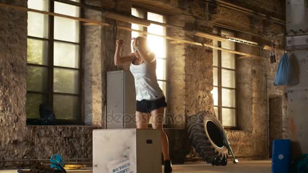 Вмістити спортсменку робить коробку стрибків у покинутому заводському тренажерному залі. Інтенсивні вправи є частиною її щоденної програми тренувань з фітнесу . — стокове відео