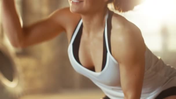 Közelről egy sportos női egy tornaterem gyakorlása során a csata kötelek a kereszt Fitness edzés alatt / nagy intenzitású intervallum képzés. Ő izmos és Sweaty, edzőterem, ipari épület. — Stock videók