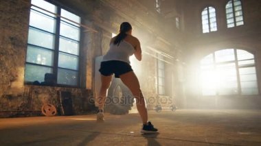 Uygun atletik kadın matkap salona Remodeled terkedilmiş bir fabrikada çalışan ayak hareketleri yapar. Fitness Egzersiz çapraz / egzersiz amaçlı bacaklar onun çeviklik ve hız arttırmak, güçlendirilmesi.