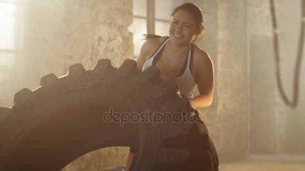 Fit Athletic Woman Lifts / Flips Tire con gran esfuerzo como parte de su entrenamiento Cross Fitness / culturismo. Trabaja en el Remade de Edificios Abandonados como Gimnasio . — Vídeos de Stock