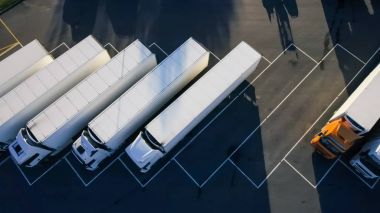 Aerial Top View of White Semi Truck with Cargo Trailer Parking with Other Vehicles on Special Parking Lot.