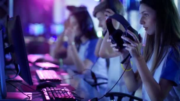 团队少女玩家做好准备电子竞技比赛，穿上他们的耳机。比赛区域 / 互联网咖啡厅看起来很酷的霓虹灯. — 图库视频影像