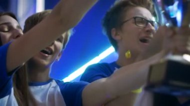 Kızlar ve çocuklar Kazananlar spor / esport / Video oyunları turnuva kutlama onların zafer, kupa kaldırma.
