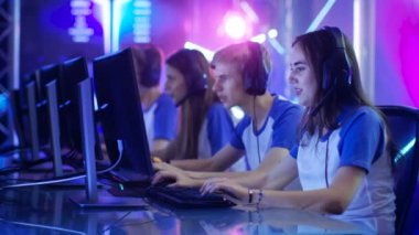 Genç oyuncular almak hazır ekibinin eSport turnuva, onların kulaklıklarda koymak. Turnuva alan / Internet Cafe Neon ışıklarla serin görünüyor.