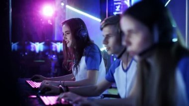 Profesyonel esport oyuncular bir siber oyunları turnuva üzerinde rekabetçi Video Oyunları'nda oynayan takım. Kızlar ve çocuklar var kulaklık üzerinde Arena Neon ışıklarla yaktı.