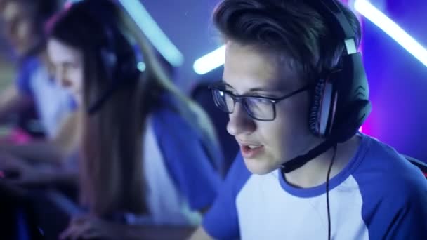 Team of Teenage Gamers Juega en un videojuego multijugador para PC en un torneo de eSport. Capitán da comandos en el micrófono, tratando de ganar estratégicamente el juego . — Vídeos de Stock