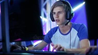 Profesyonel çocuk oyun oynuyor Video oyunundan bir esports turnuva / Internet Cafe. O kulaklık takıyor ve komutları mikrofona konuşur. 