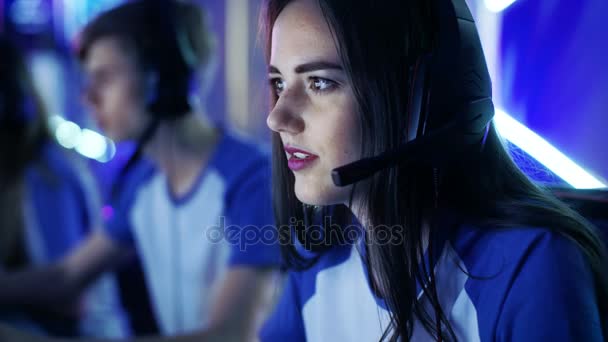 美丽的专业玩家女孩和她的团队参加电子竞技网络游戏比赛。她有她的耳机和作为一个团队领导者，她命令战略演习，麦克风. — 图库视频影像