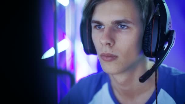 Bliska strzał Professional chłopiec Gamer odgrywa w grze wideo na esports turnieju / w Internet Cafe. Nosi słuchawki i daje polecenia do mikrofonu. — Wideo stockowe