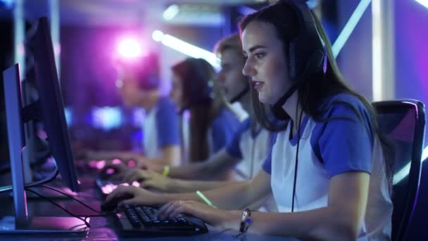 Equipo de jugadores profesionales de eSport que juegan MMORPG competitivo / videojuego de estrategia en un torneo de juegos cibernéticos. Se hablan en micrófonos. Arena se ve bien con luces de neón . — Vídeos de Stock