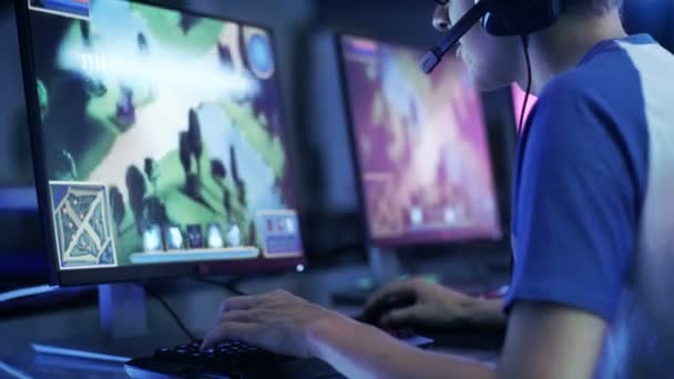 Professional Gamer Participates in eSport in Competitive MMORPG/ Strategy Video Game Cyber Games Tournament/ or Plays in Local Internet Cafe. Arena Looks Cool with Neon Lights. — Stock Video