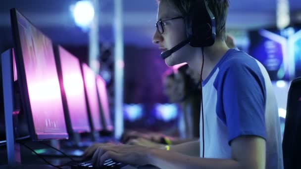 Team van professionele esport Gamers spelen in concurrerende Mmorpg / strategie Video Game op een Cyber Games-toernooi. Ze praten met elkaar in microfoons. Arena ziet er Cool met Neon verlichting. — Stockvideo