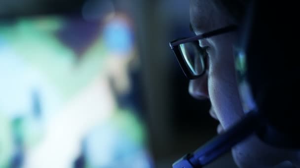 专业玩家戏剧在 Mmorpg / 战略视频游戏在他的电脑上。他参加在线网络游戏比赛，戏剧在家里，或在互联网咖啡馆。他戴着眼镜和游戏耳机. — 图库视频影像