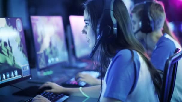 Bella ragazza giocatore professionista e la sua squadra partecipare a eSport Cyber Games Tournament. Ha le cuffie e parla in microfono . — Video Stock