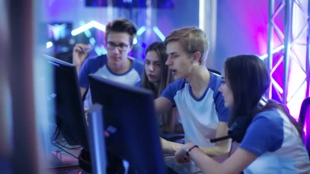 Team av professionella pojkar och flickor Gamers aktivt tänkande / diskutera spel strategi / taktik, de är i Internet Cafe eller på Cyber Games turnering. — Stockvideo