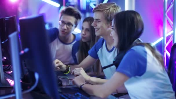 Equipo de jugadores profesionales de los muchachos y las muchachas que piensan activamente / que discuten estrategia / táctica del juego, están en el café del Internet o en torneo de los juegos cibernéticos . — Vídeos de Stock