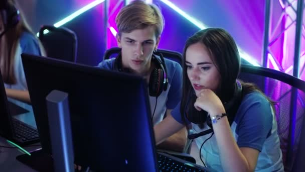 Pojke och flicka Gamers aktivt tänkande / diskutera spel strategi / taktik, de är i Internet Cafe eller på Cyber Games turnering. — Stockvideo