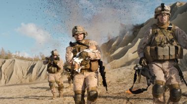 Patlamalar uzak bir bebek taşıma arkasında çalışan asker. WHI