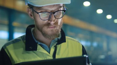 Kask mühendisi bir ağır mühendisli tablet bilgisayar kullanıyor