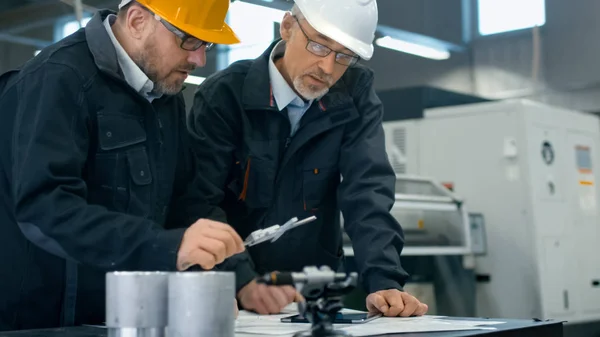 Dos ingenieros discuten un plan mientras verifican la información sobre — Foto de Stock