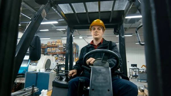 Retrato de un trabajador de almacén conduciendo una carretilla elevadora . — Foto de Stock