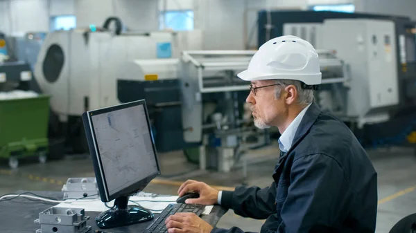 Ingeniero sénior en gafas está trabajando en una computadora de escritorio en un — Foto de Stock