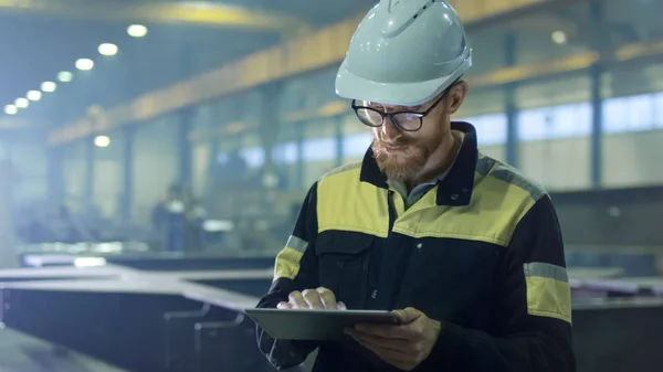 Ingeniero en hardhat está utilizando una tableta en una industria pesada — Foto de Stock