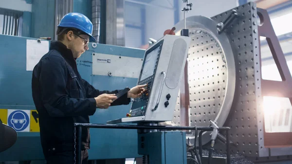 Trabalhador da fábrica está programando uma máquina de fresagem CNC com uma mesa — Fotografia de Stock