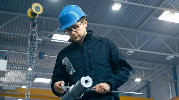 Fabrieksarbeider is het maken van een controle van de kwaliteit van een metalen detail wit — Stockfoto