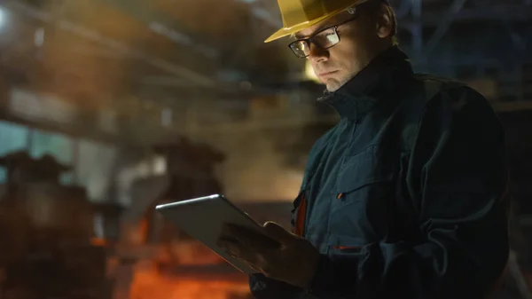 Ingenieur in Brillen mit Tablet-PC in der Gießerei. Industrieumfeld — Stockfoto