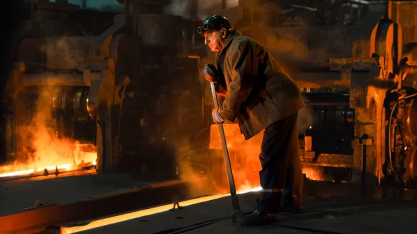 Tung industri arbetare gör kvalitetskontroll i gjuteri. Grov — Stockfoto