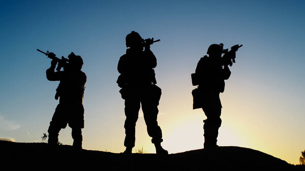 Отряд из трех полностью экипированных и вооруженных солдат, стоящих в Дес
