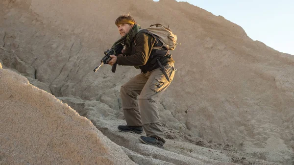 Terroriste armé marchant dans un environnement désertique — Photo