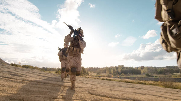 Squad of Fully Equipped and Armed Soldiers Running in Single Fil