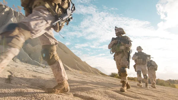 Esquadrão de soldados totalmente equipados e armados que se deslocam em um único arquivo — Fotografia de Stock