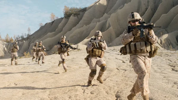Διμοιρία των πλήρως εξοπλισμένη, οπλισμένοι στρατιώτες που τρέχει στην έρημο. S — Φωτογραφία Αρχείου
