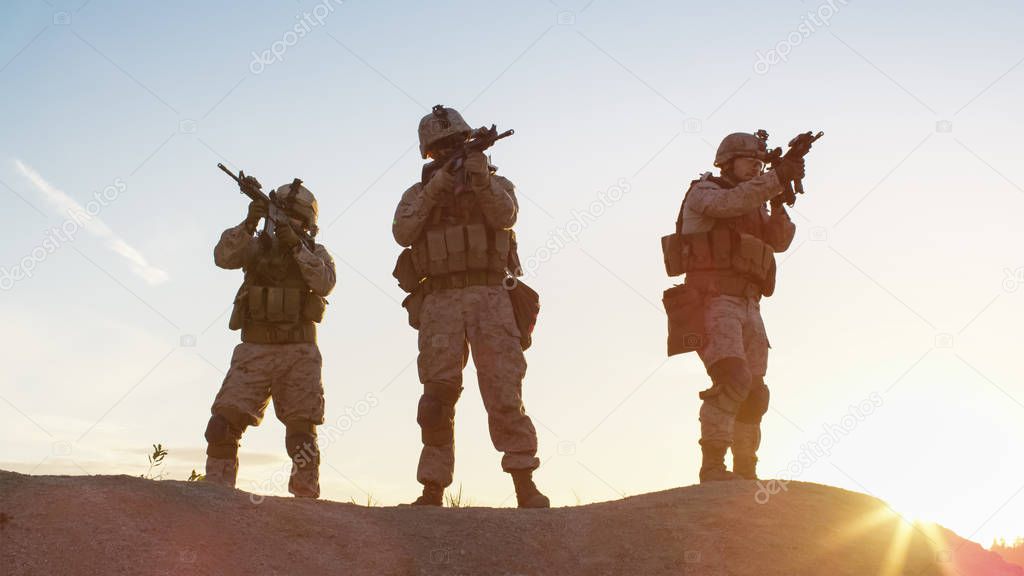 Squad of Three Fully Equipped and Armed Soldiers Standing on Hil