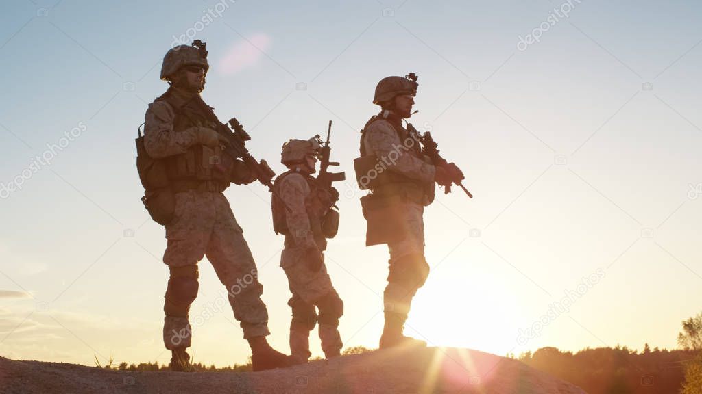 Squad of Three Fully Equipped and Armed Soldiers Standing on Hil