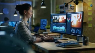 Güzel kadın Video editörü görüntüleri ile kişisel bilgisayarında çalışır, o yaratıcı Office stüdyoda çalışıyor.