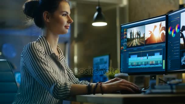 Vrouwelijke videoredacteur werken met beelden en geluid op haar Personal Computer. Haar kantoor is Modern en creatieve Loft Studio. — Stockvideo