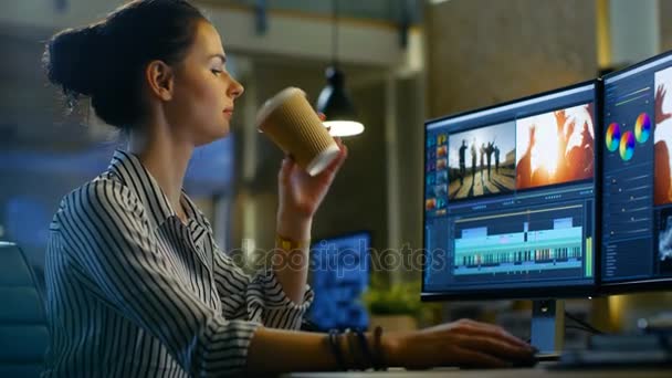 Editor de Vídeo Feminino Trabalha com Filmagem e Som em seu Computador Pessoal. Ela trabalha tarde e bebe café. Seu escritório é moderno e criativo Loft Studio . — Vídeo de Stock