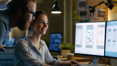 Kadın Ux mimar erkek tasarım mühendisi ile tartışma vardır, gece geç saatte mobil uygulama üzerinde çalışırlar, kahve içiyor. Proje yapışkan notlar ile arka duvarında.