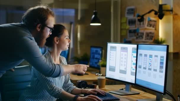 Female UX Architect Has Discussion with Male Design Engineer, They Work on Mobile Application Late at Night, She Drinks Coffee. In the Background Wall with Project Sticky Notes. — Stock Video