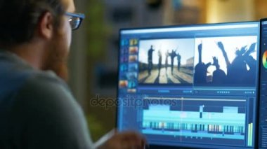 Erkek Video Editor görüntüleri ve ses ile iki göstermek onun kişisel bilgisayarda çalışır. O serin Office çatı katında çalışıyor.