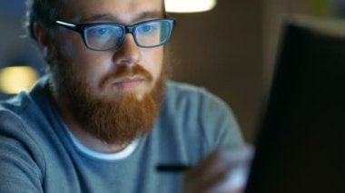 Yetenekli genç kavramı sanatçı çizim Modern Loft Office çalışma evinde otururken bir dijital kalem ekran tablet. Gece geç saatte.