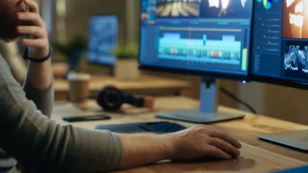 Male Videographer Edits and Cuts Footage and Sound on His Personal Computer with Two Displays. His Office is Modern and Creative Loft Studio. — Stock Video