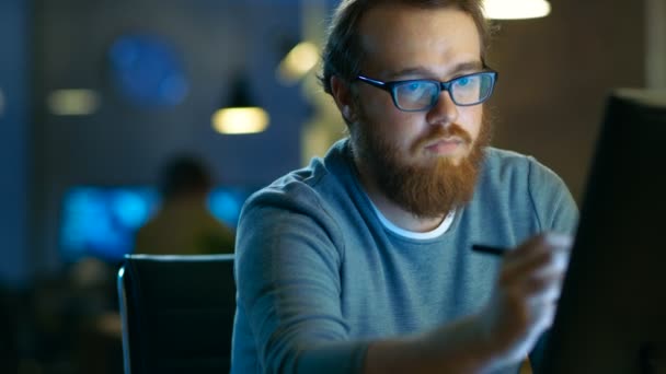 Talentierter junger Konzeptkünstler, der an seinem Arbeitsplatz im modernen Loft-Büro auf einem Tablet mit digitalem Stift zeichnet. spät in der Nacht. — Stockvideo