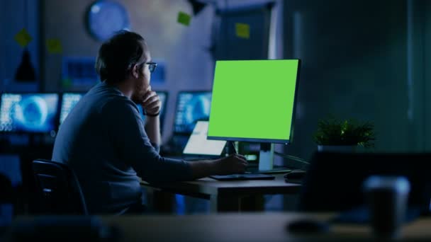 El hombre barbudo creativo trabaja en una computadora personal con pantalla verde simulada aislada. Trabaja solo en la oficina hasta tarde en la noche . — Vídeos de Stock